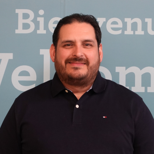 An employee in a polo shirt poses for a portrait