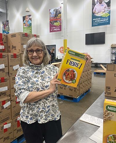 Volunteer holding box of cereal