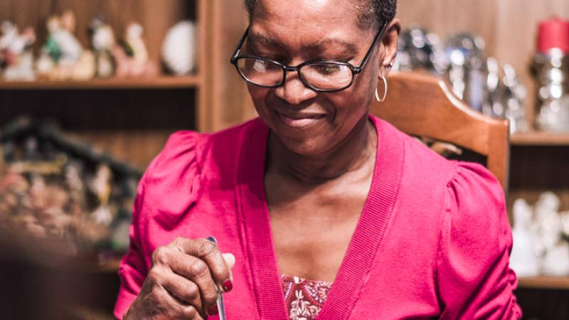 A senior woman eats a prepared meal in her home