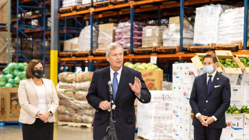 Three people stand in a warehouse