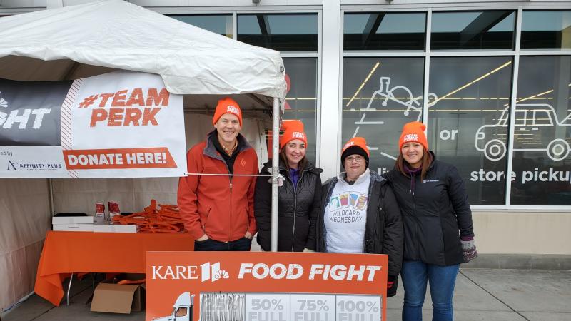 A group of people stand outside grocery store