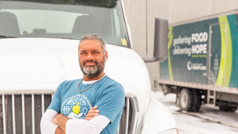 A man stands in front of a semi truck