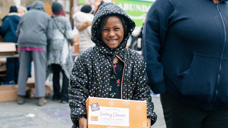 A child holds a box and smiles