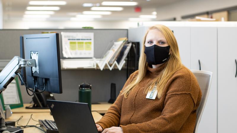 Volunteer sits at a computer desk