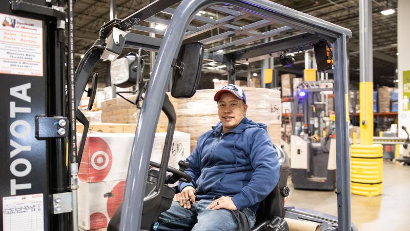 An employee sits on a fork lift