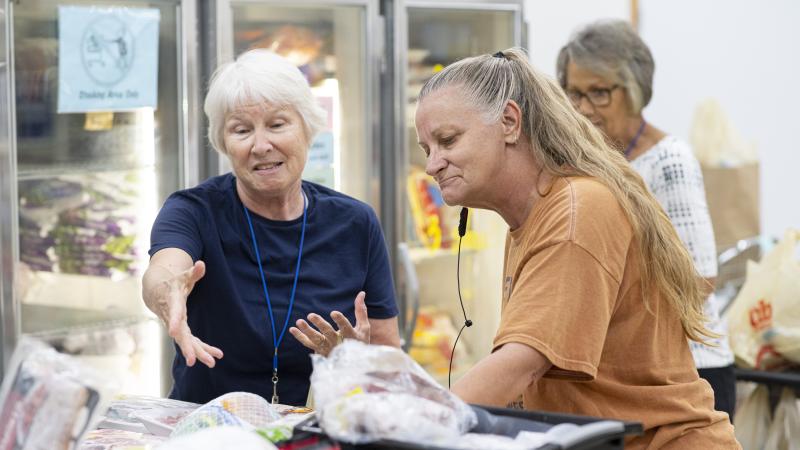 An older woman getting help shopping at a food shelf
