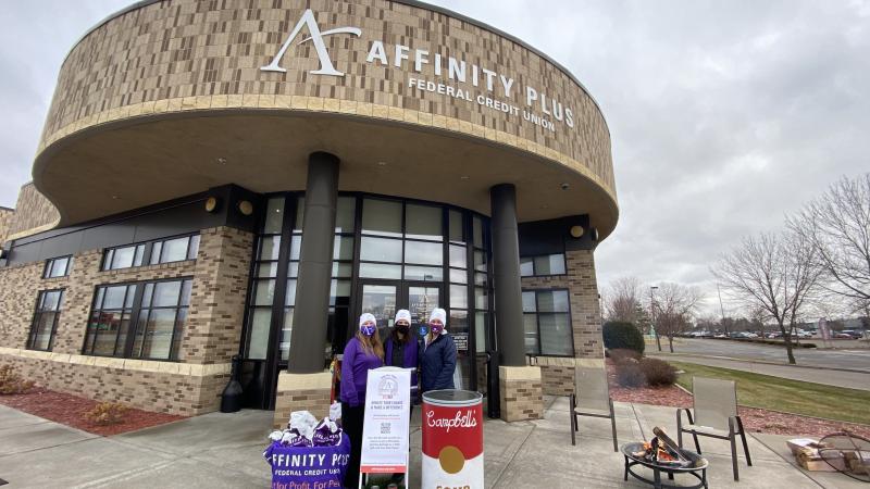 Affinity Plus members in front of branch entrance, collecting coins