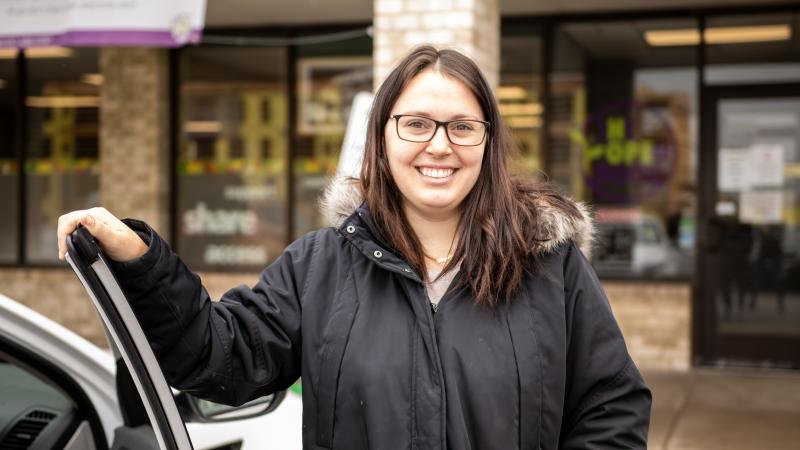woman standing in front of food shelf smiling