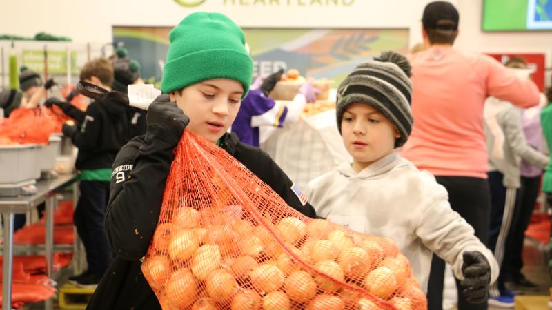 Two kids pack potatoes