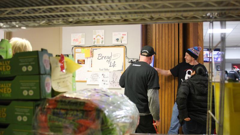 Volunteers helping a shopper at Bread of Life Food Pantry