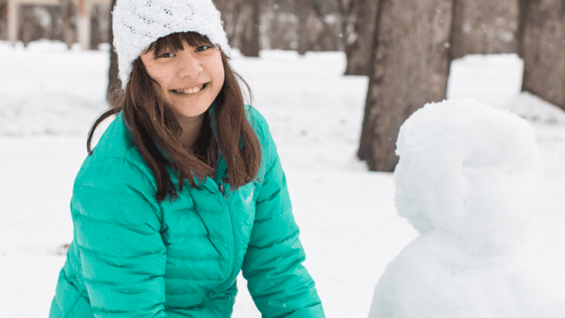 Girl building snowman
