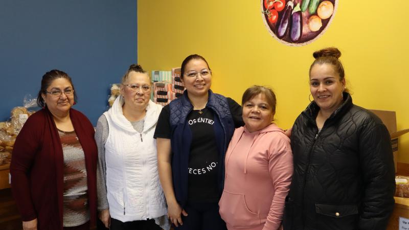 A group of five women posing in a food shelf