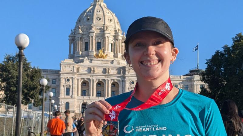 Person with their finishers medal from the Twin Cities Marathon