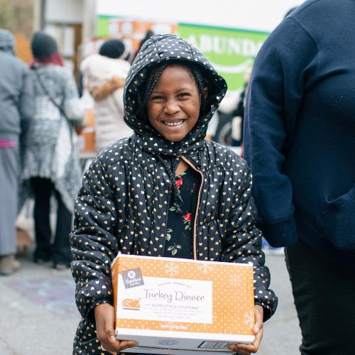 A child holds a box and smiles