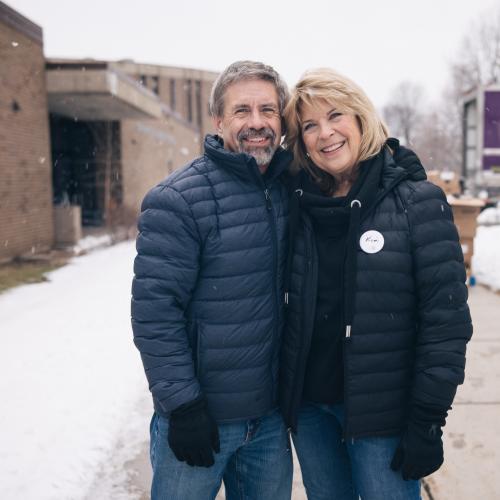 An older couple volunteers outside at winter food distribution