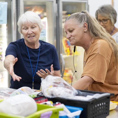 An older woman getting help shopping at a food shelf