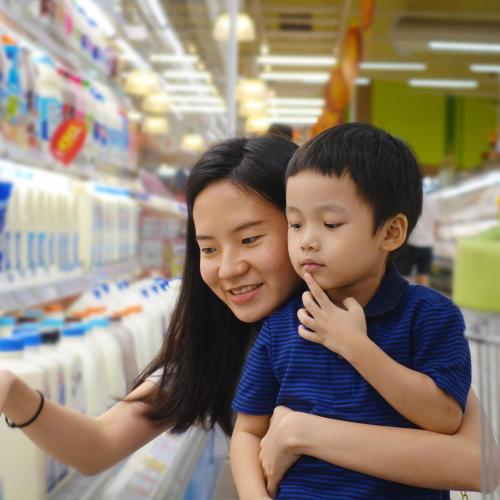 Mom and child shop for milk at grocery store