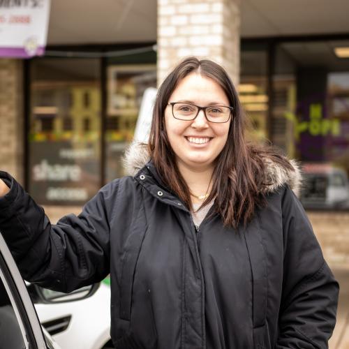 woman standing in front of food shelf smiling