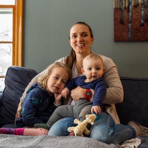 Mother with her two children sitting on a couch