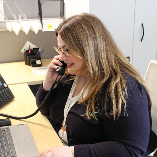 Desiree Olson, a Strategic Partners Supervisor, on the phone in her office