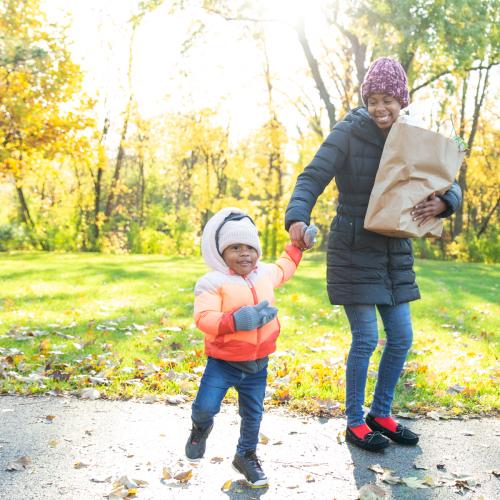 Mom and child in fall weather carrying groceries