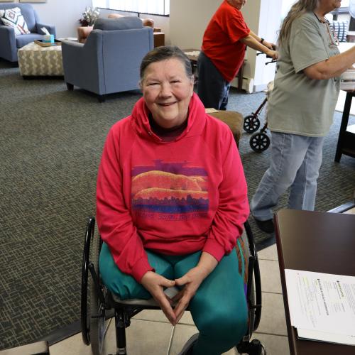 Smiling woman in a red sweatshirt in a wheelchair