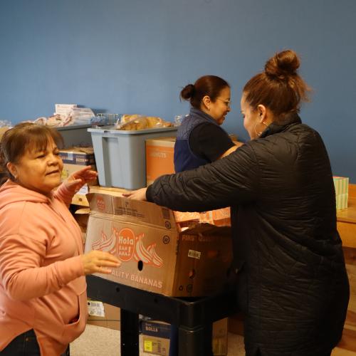 A group of women putting food in boxes