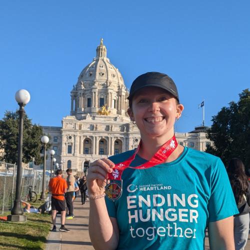 Person with their finishers medal from the Twin Cities Marathon