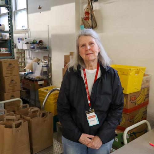 A volunteer fills grocery bags at a food shelf
