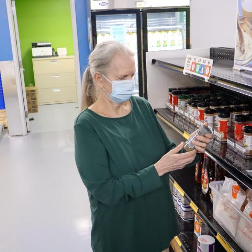A woman in a face mask shops for spices