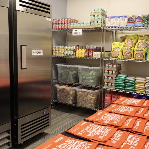Shelves of food, both fresh and shelf-stable, and silver industrial coolers
