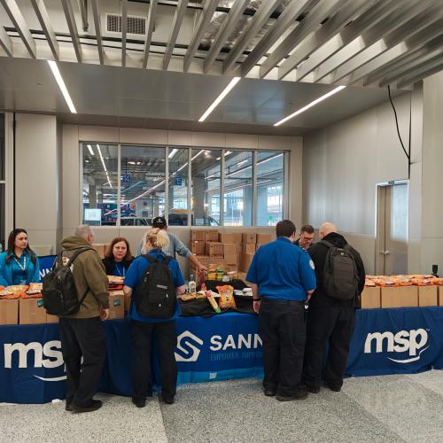 People in front of table full of emergency boxes of food