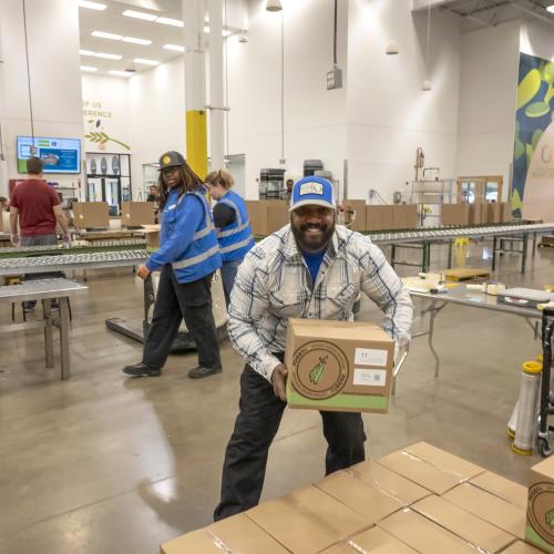 Volunteer holding a box of packed food