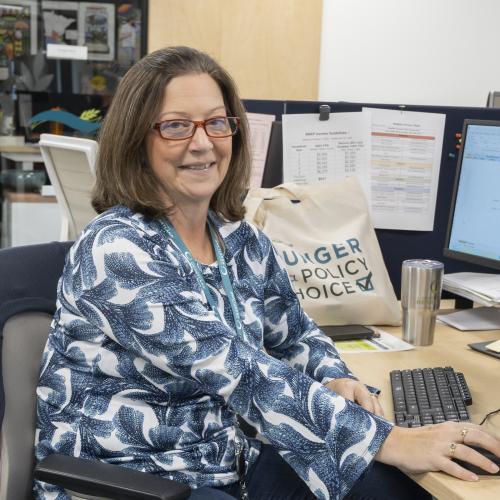 Volunteer posing for a picture while working on a computer