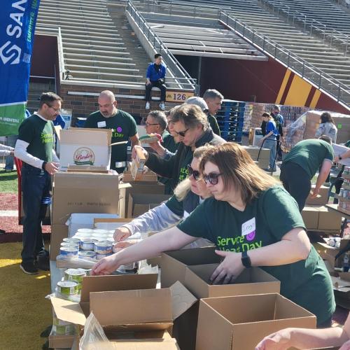 Volunteers packing food boxes in Huntington Bank Stadium