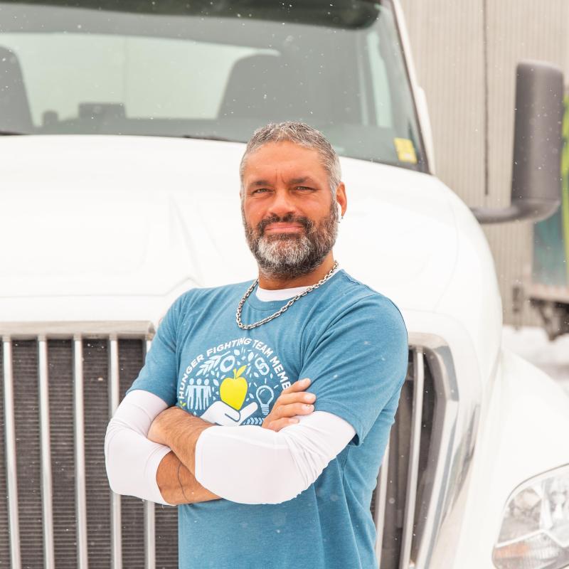 A man stands in front of a semi truck