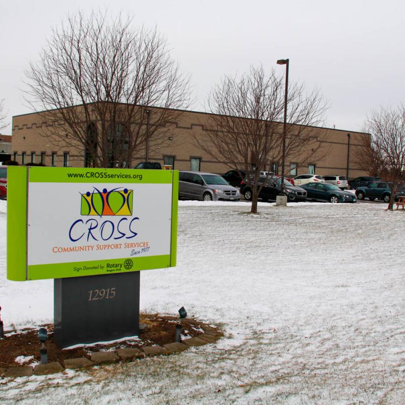 A sign reading, "CROSS" in front of a building