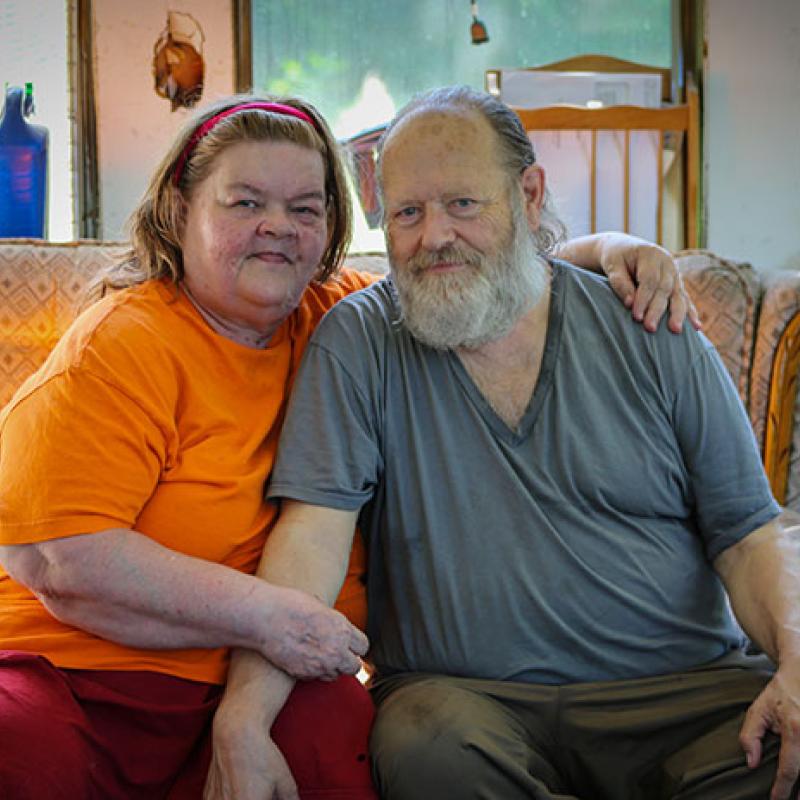 James and Toianne sitting on a sofa in a living room