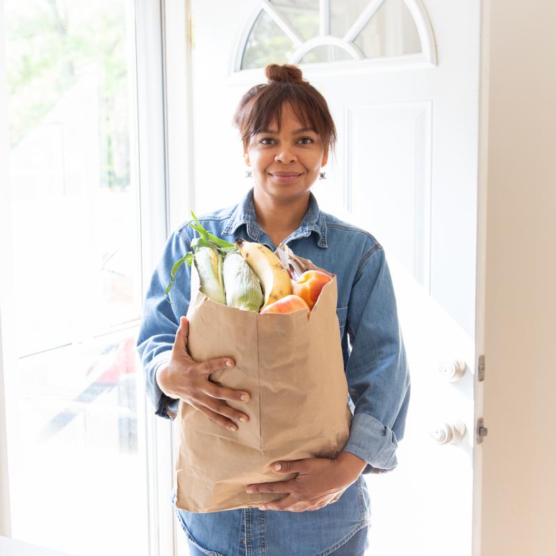 Woman with a bag of groceries in her kitchen