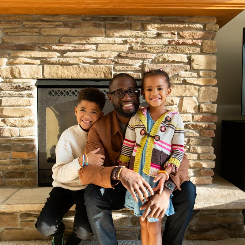 Family sitting infront of fireplace
