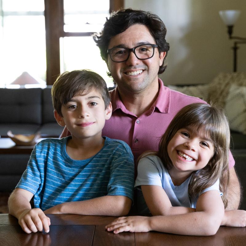 3 people seated in room - 2 children and one adult