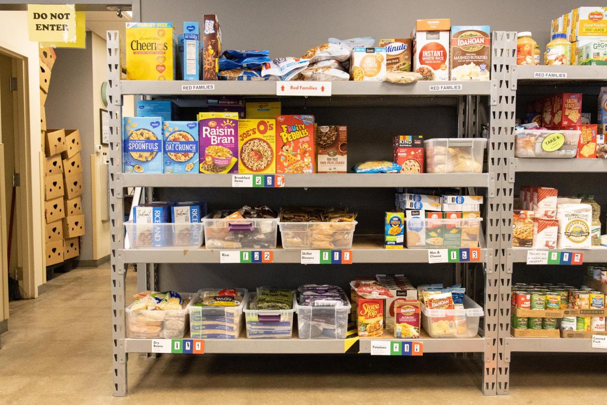 Shelves of food at a food pantry including cereal, pasta and more