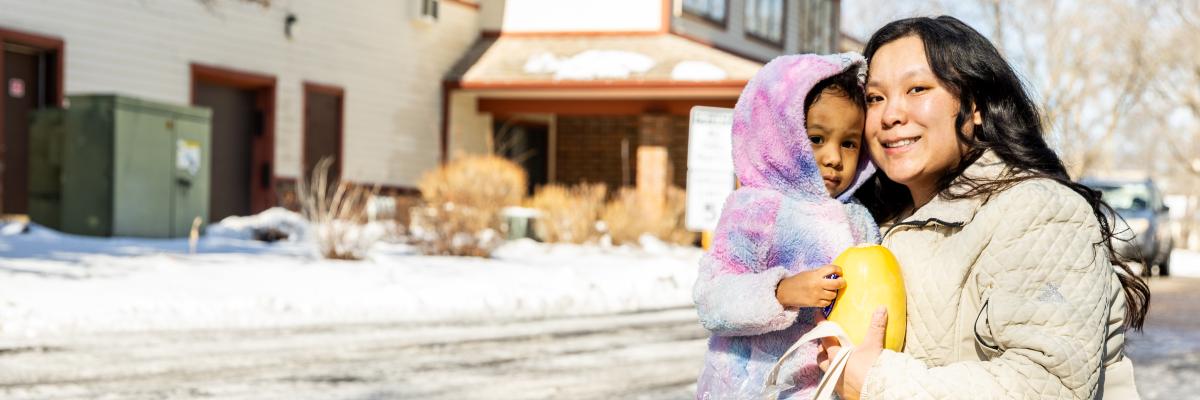 Adult and child outside in winter weather with groceries
