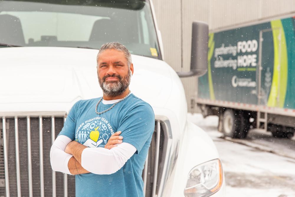 A man stands in front of a semi truck