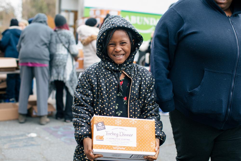 A child holds a box and smiles