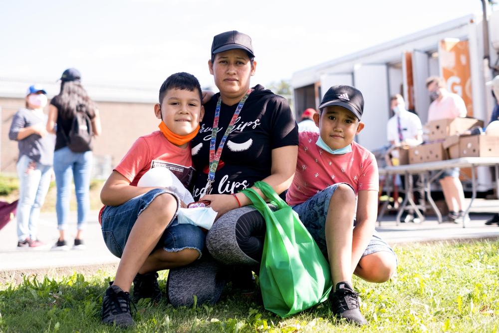 A mom and her children gather together at a food distribution event