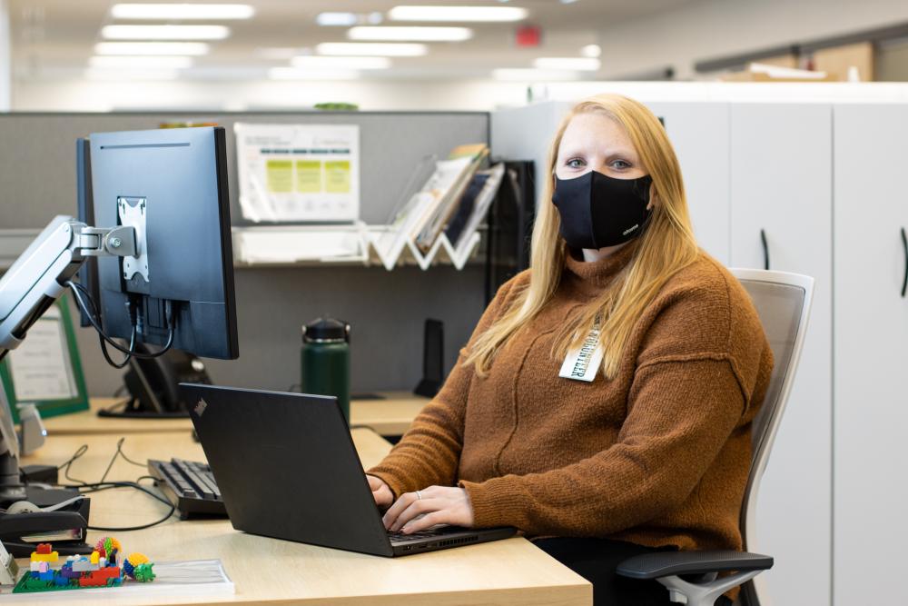 Volunteer sits at a computer desk