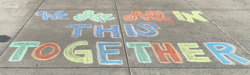 Chalk art that says, "We are all in this together"