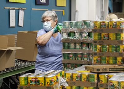 volunteer packing boxes of canned food
