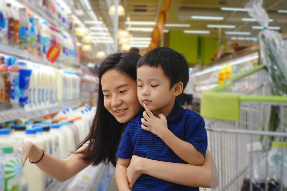 Mom and child shop for milk at grocery store